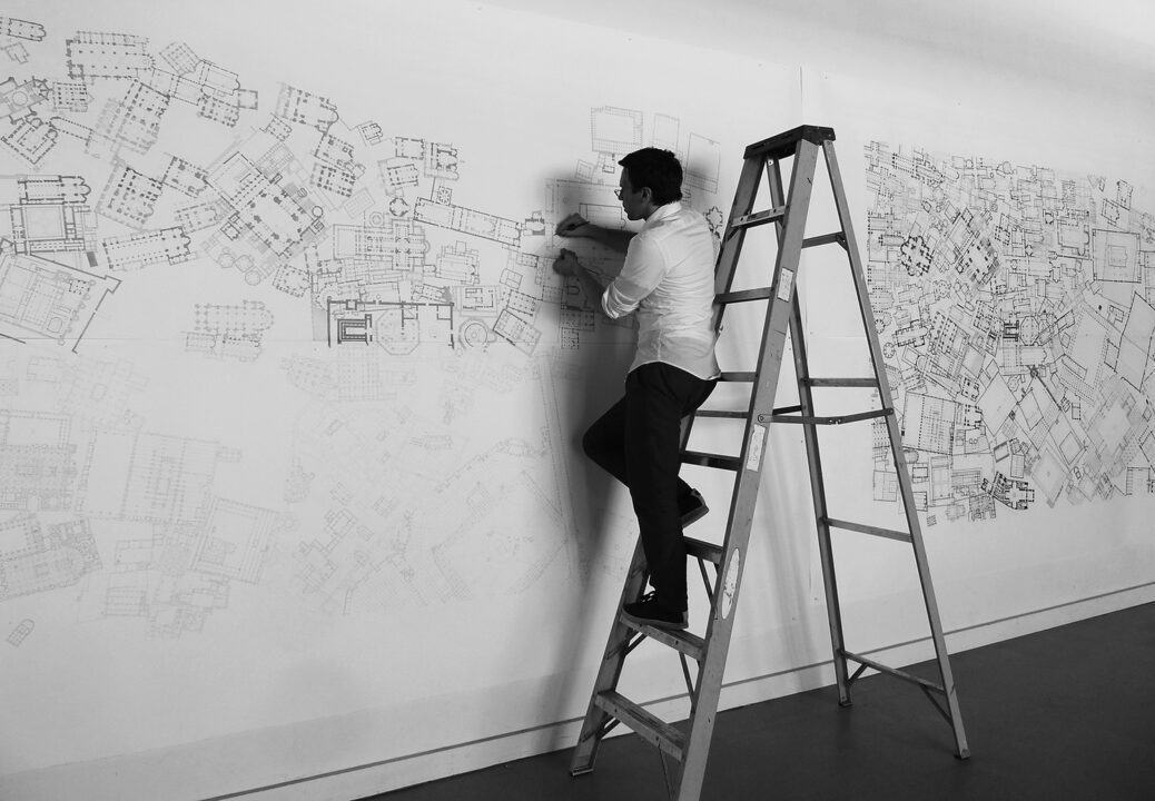 Photo of Mark Baechler drawing on a wall