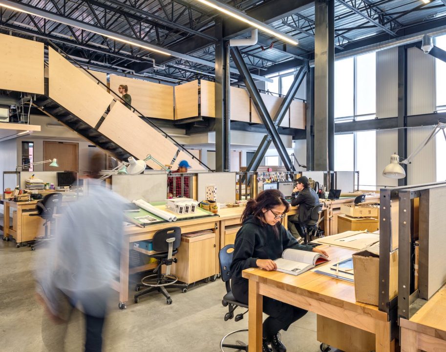 Photograph of students at their desks in a studio space