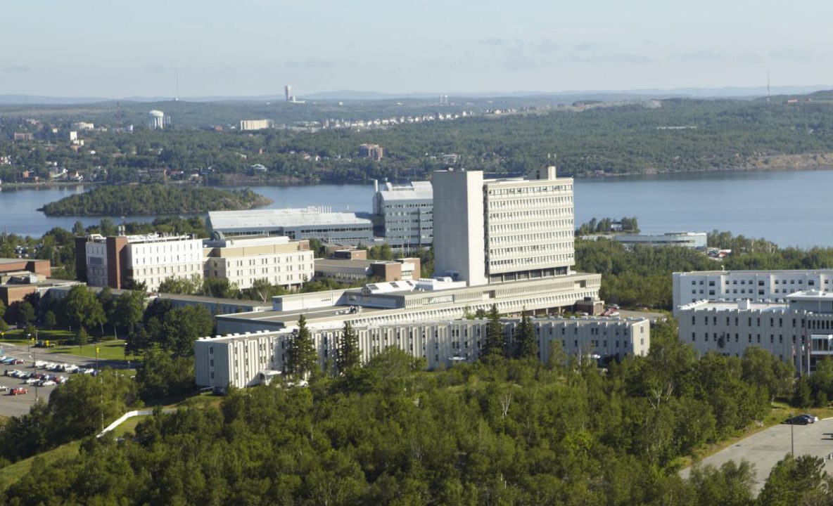 Photograph looking down on a large building surrounded by trees