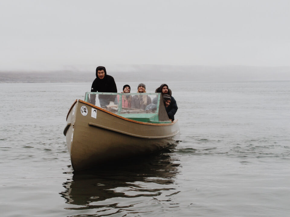 Photograph of students being driven by community members through a large body of water