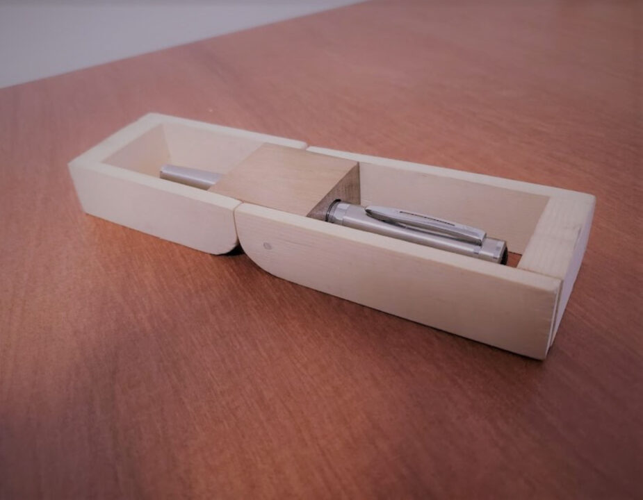 Photograph of a wooden box holding a pen