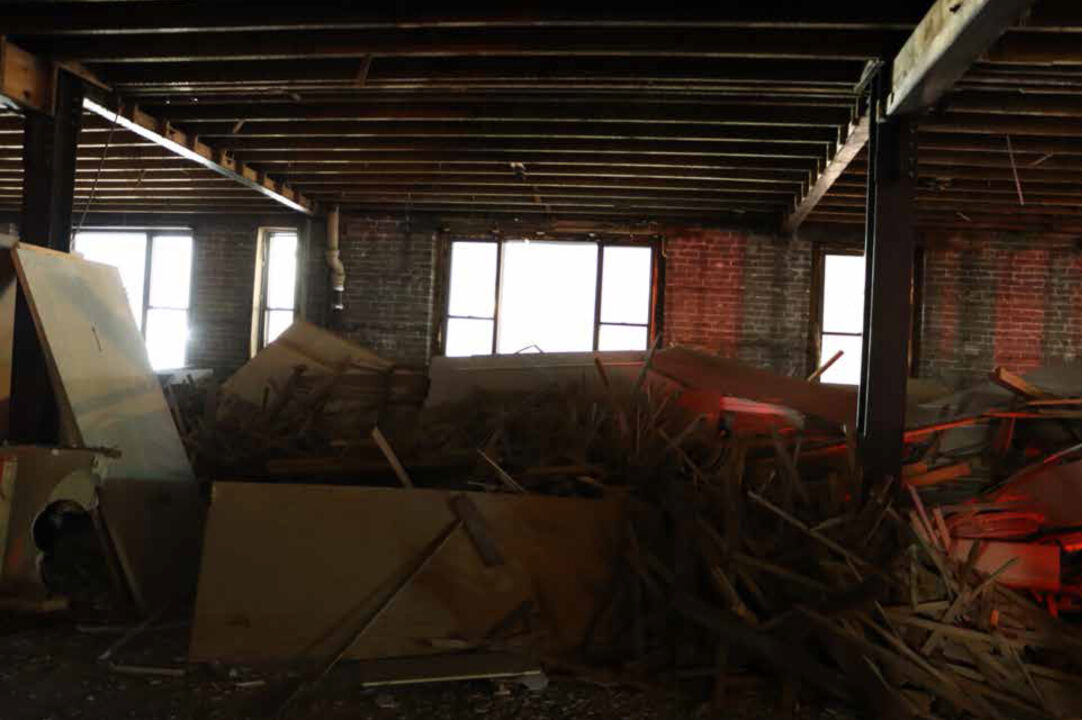 Photograph of a pile of scrap metal and plywood in an abandoned building