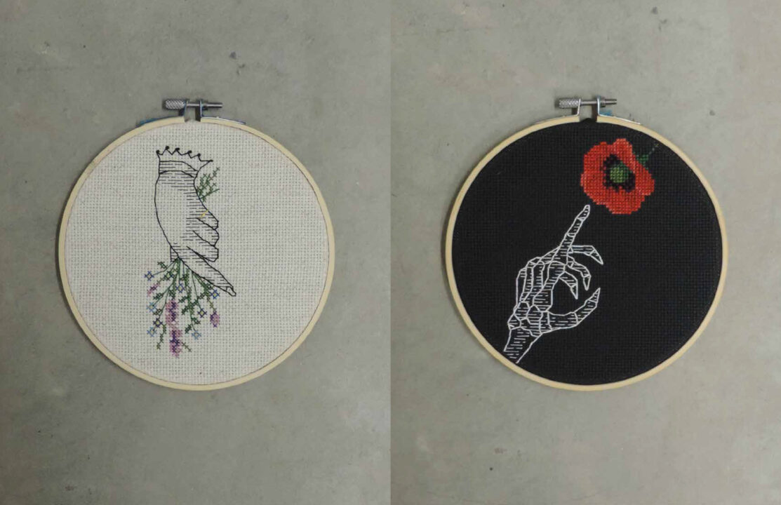 Photograph of two embroidery circles, one with a hand holding flowers and the other of a skeleton hand reaching towards a rose