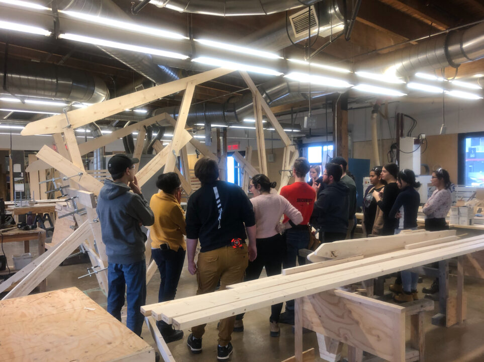 Photograph of students standing around their wooden ice station in a workshop